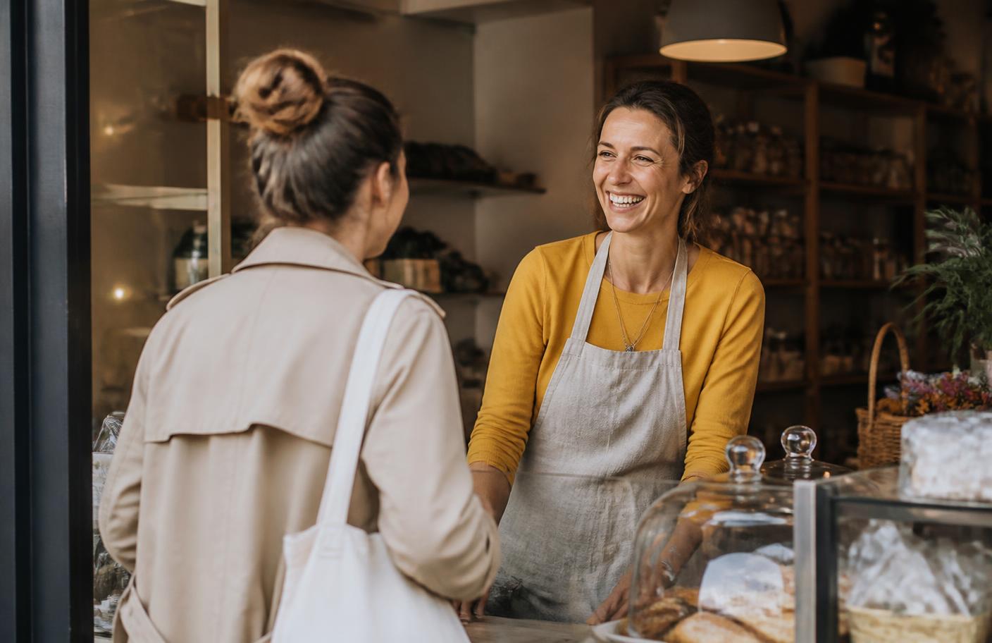 Une commerçante accueille une cliente habituée dans sa boutique